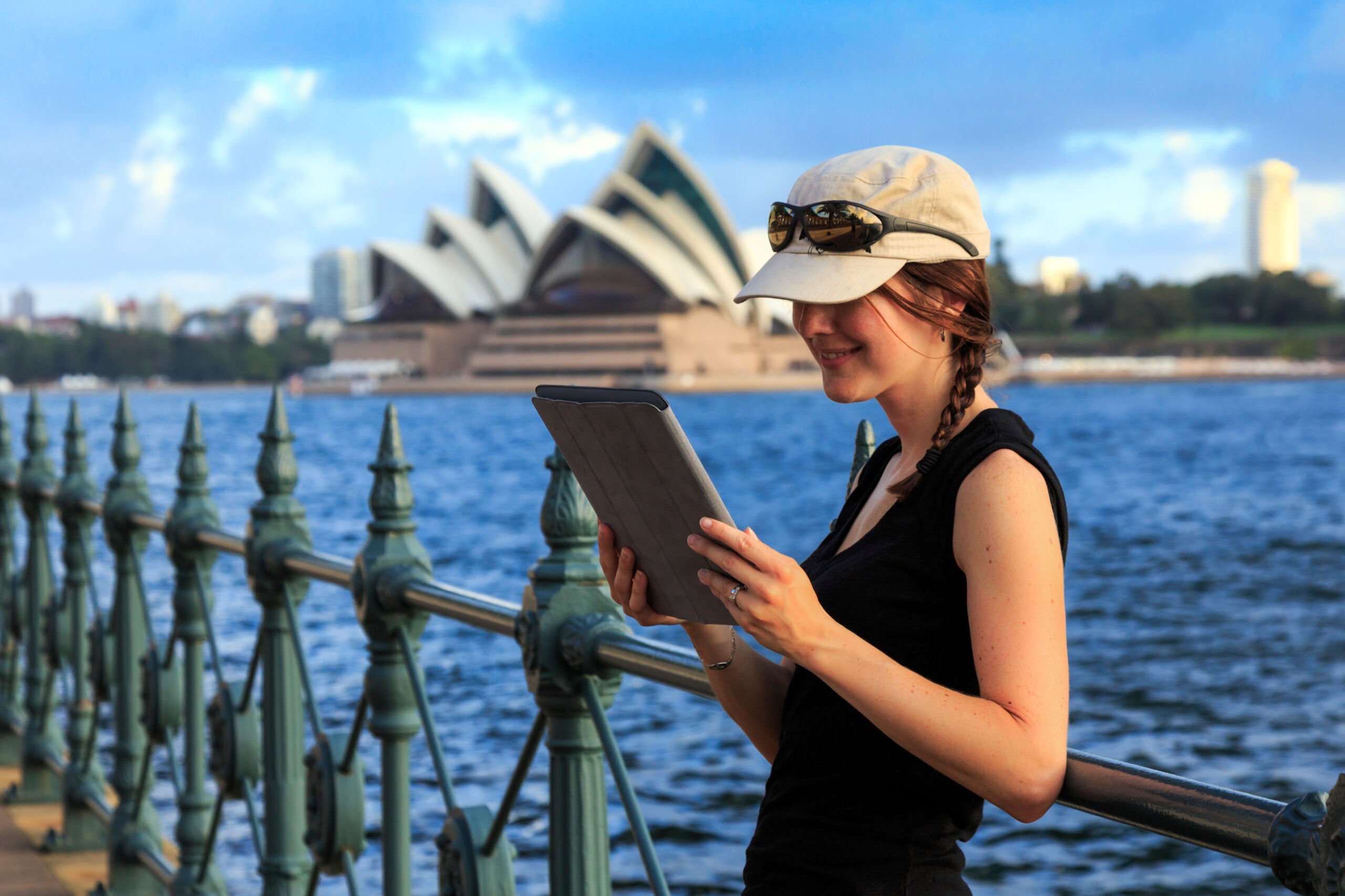 woman using electronic tablet in sydney with opera house, australia