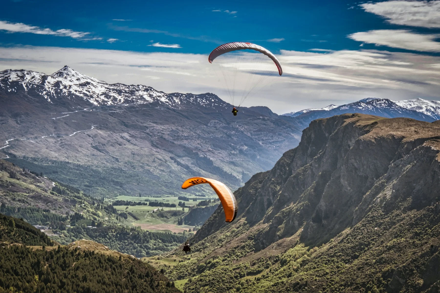 person in yellow parachute over mountains during daytime