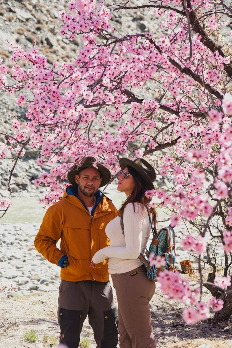 PVT en couple - deux voyageurs avec sacs à dos sous les cerisiers en fleurs